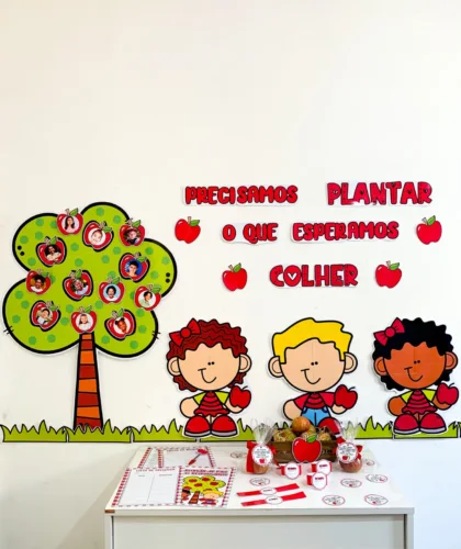 Painel decorativo com frases e desenhos de crianças e árvores com fotos em maçãs